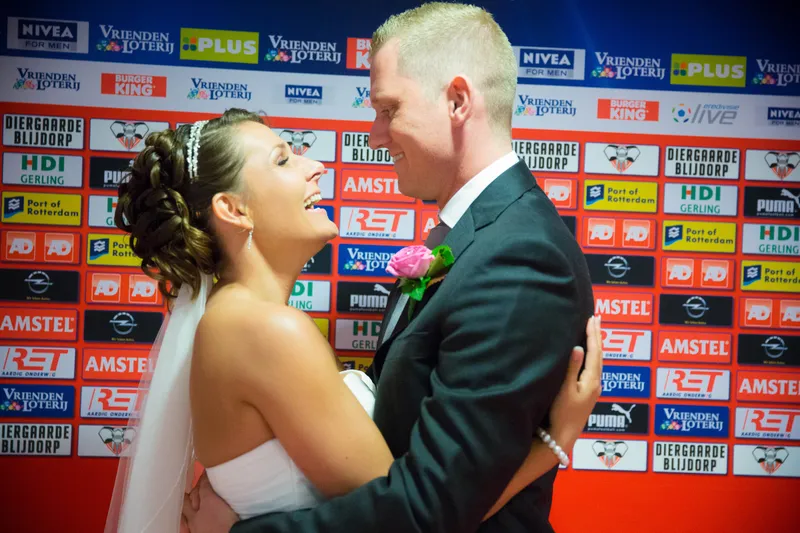 Michelle en Sven lachen voor de perswand met sponsorlogo’s