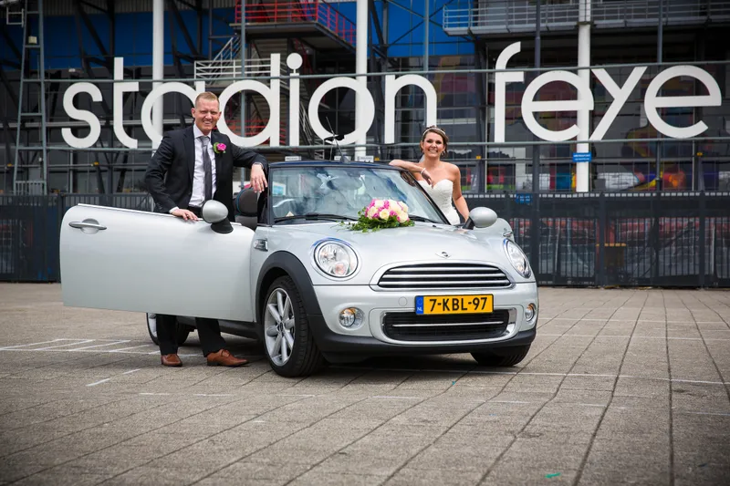 Michelle en Sven bij hun Mini-cabrio voor de letters Stadion Feijenoord
