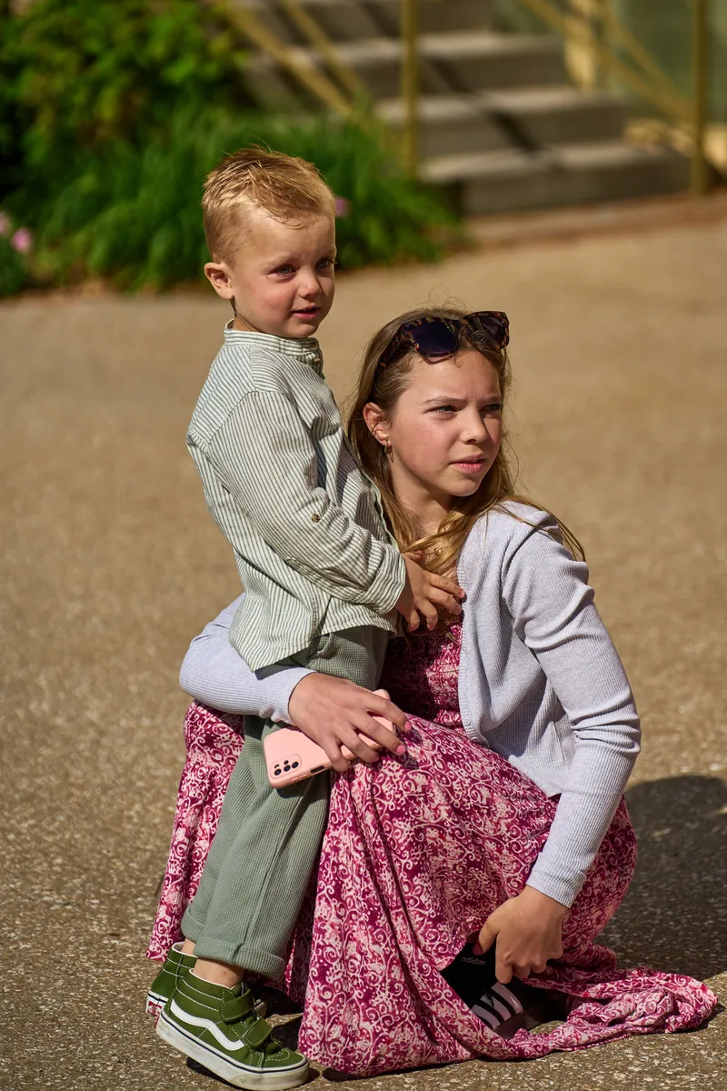 Een meisje met een jongetje op schoot in de zon