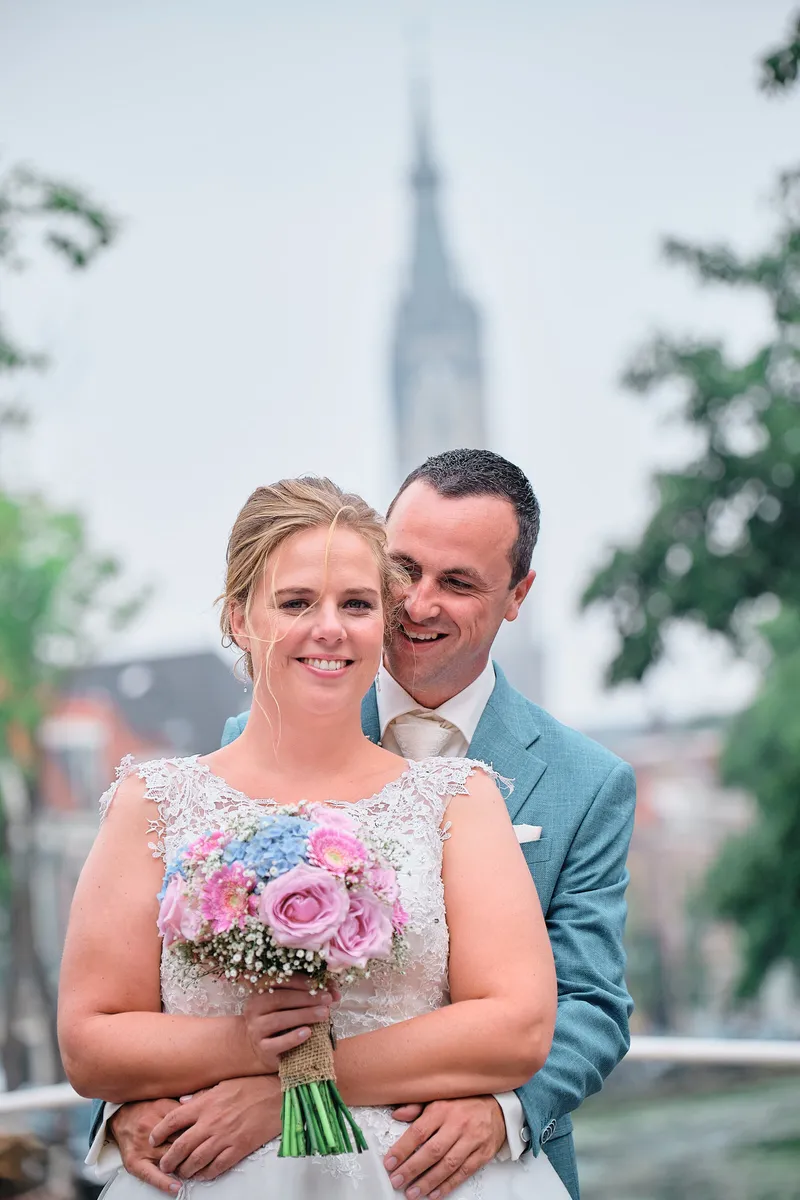 Milou lacht met haar roze boeket, Rick achter haar
