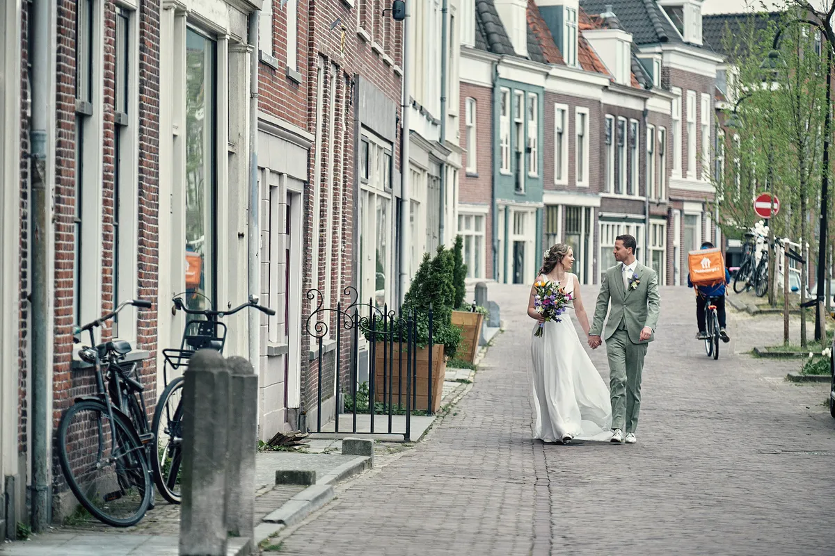 Renske en Tijmen lopen door een Delftse straat met geveltjes en fietsen