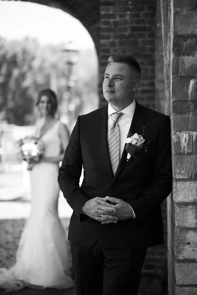 Zwart-wit: Richard onder een stenen boog, Ingrid met het boeket achter hem