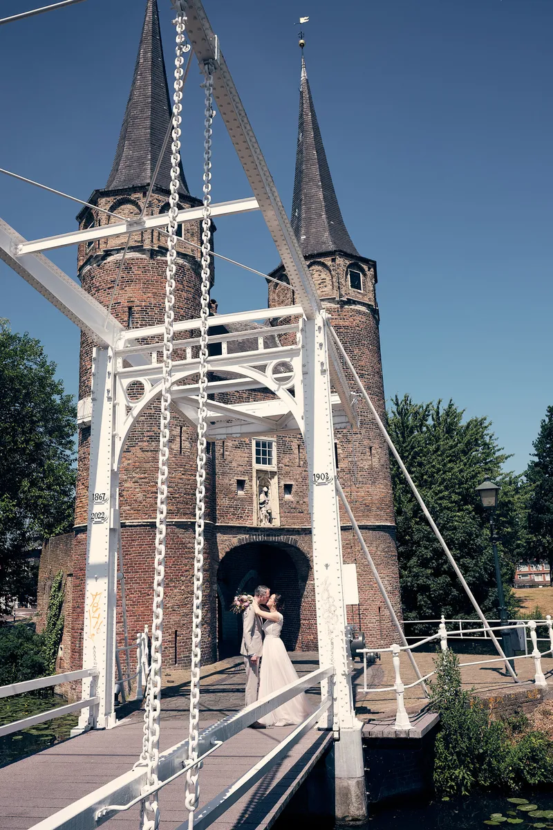Evelien en Krijn onder de witte ophaalbrug, met de torens van de Oostpoort erachter