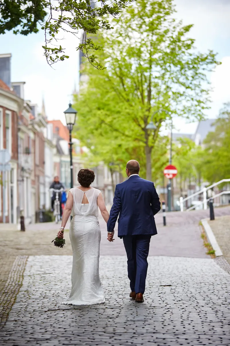 Marina en Erik lopen hand in hand door een straat in Delft