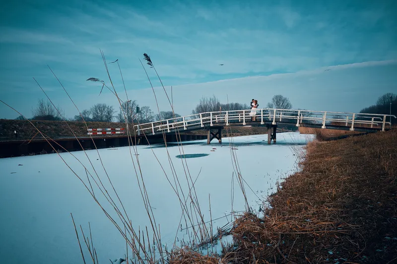 Naomi en Maurice op de witte brug over het bevroren water