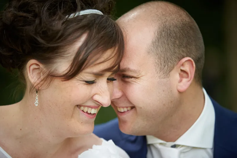Close-up van Marina en Erik, hoofden tegen elkaar, lachend