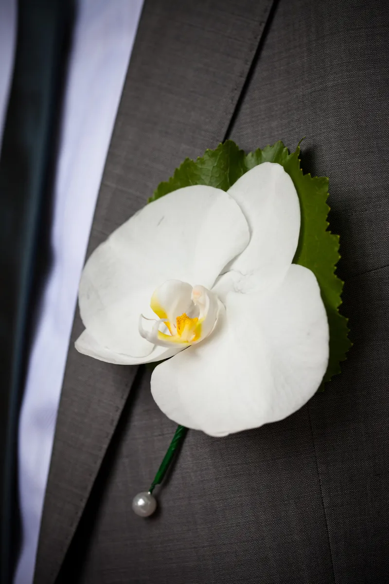 Een witte orchidee op de revers van Ivan