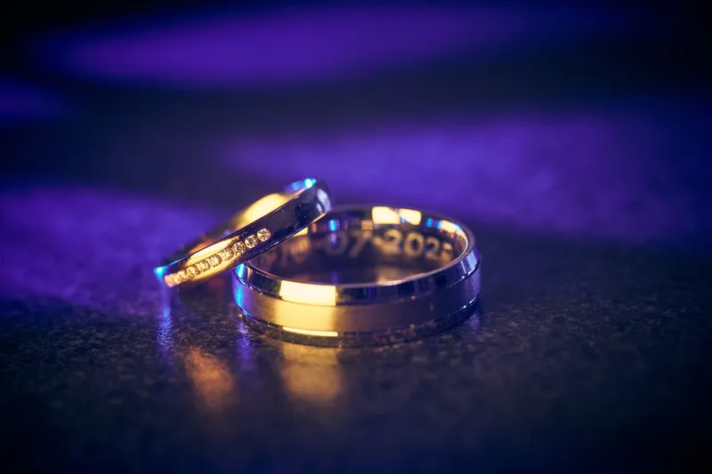 De twee gouden trouwringen in paars licht