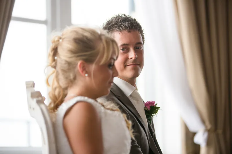 Linda en Alex luisteren naar de trouwambtenaar