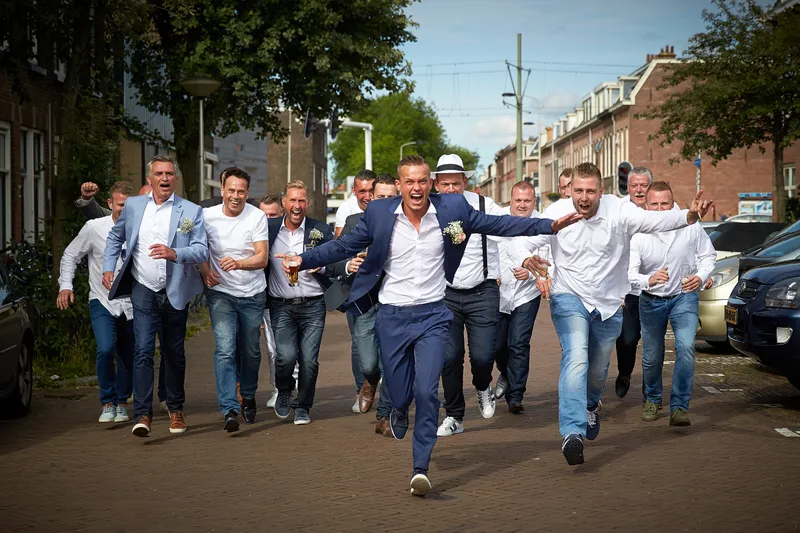 De mannen lopen lachend door de straat