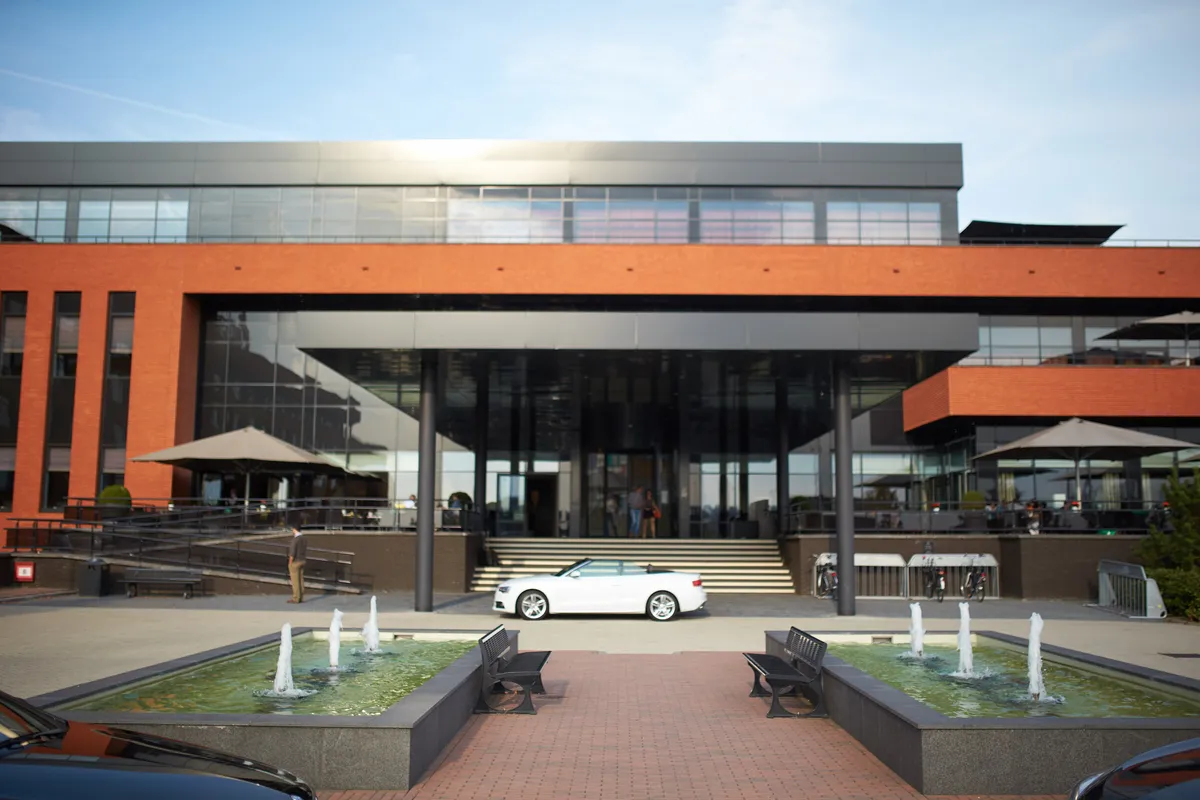 De witte Audi voor de moderne gevel van het hotel