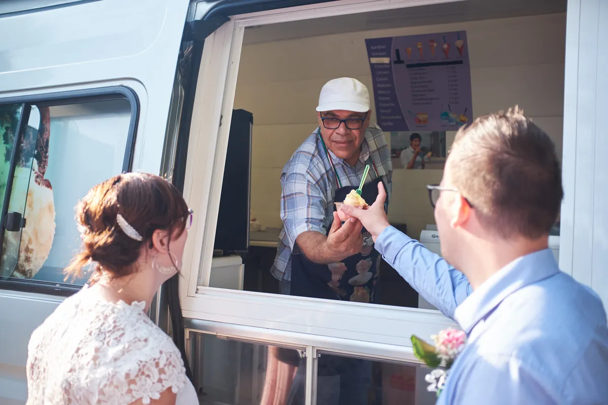 De ijscoman geeft Kevin een ijsje vanuit zijn kraam