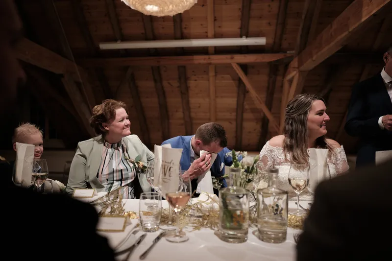 Gasten lachen aan tafel tijdens het diner