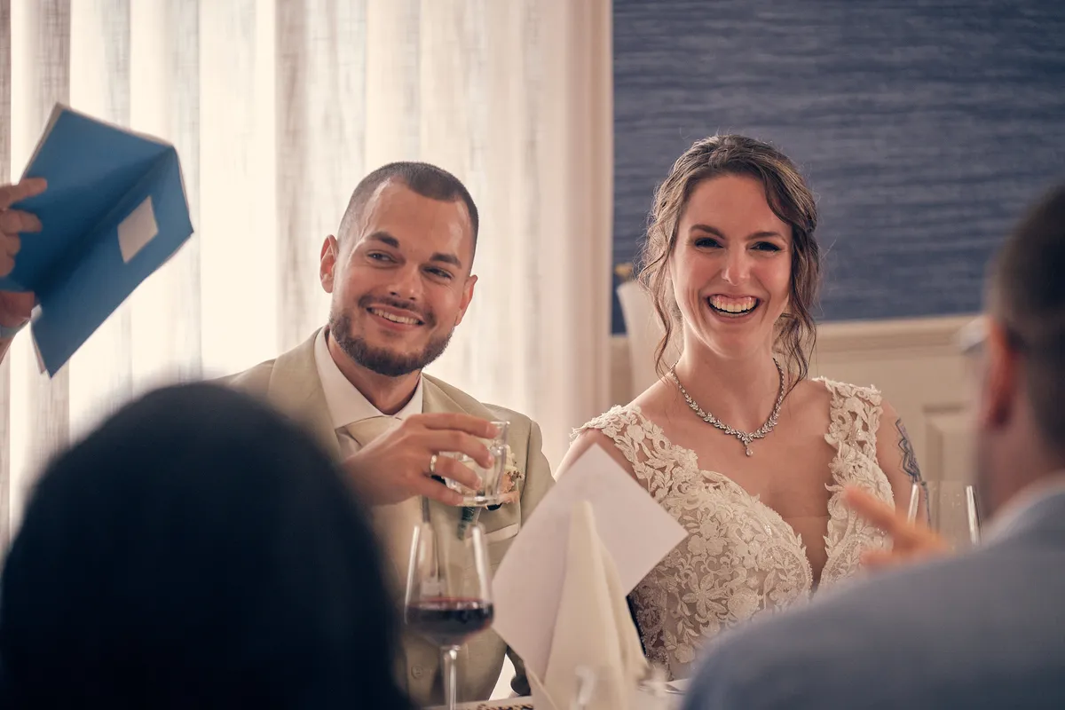 Wendy en Robin lachen aan tafel tijdens een speech
