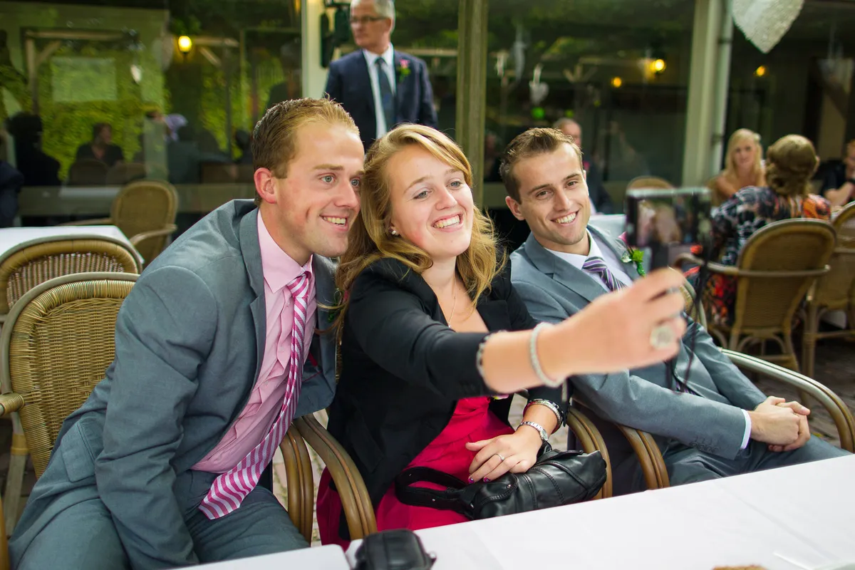 Gasten maken een selfie aan tafel tijdens het diner