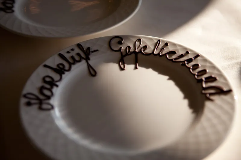 Een bord met ‘Hartelijk gefeliciteerd’ in chocolade