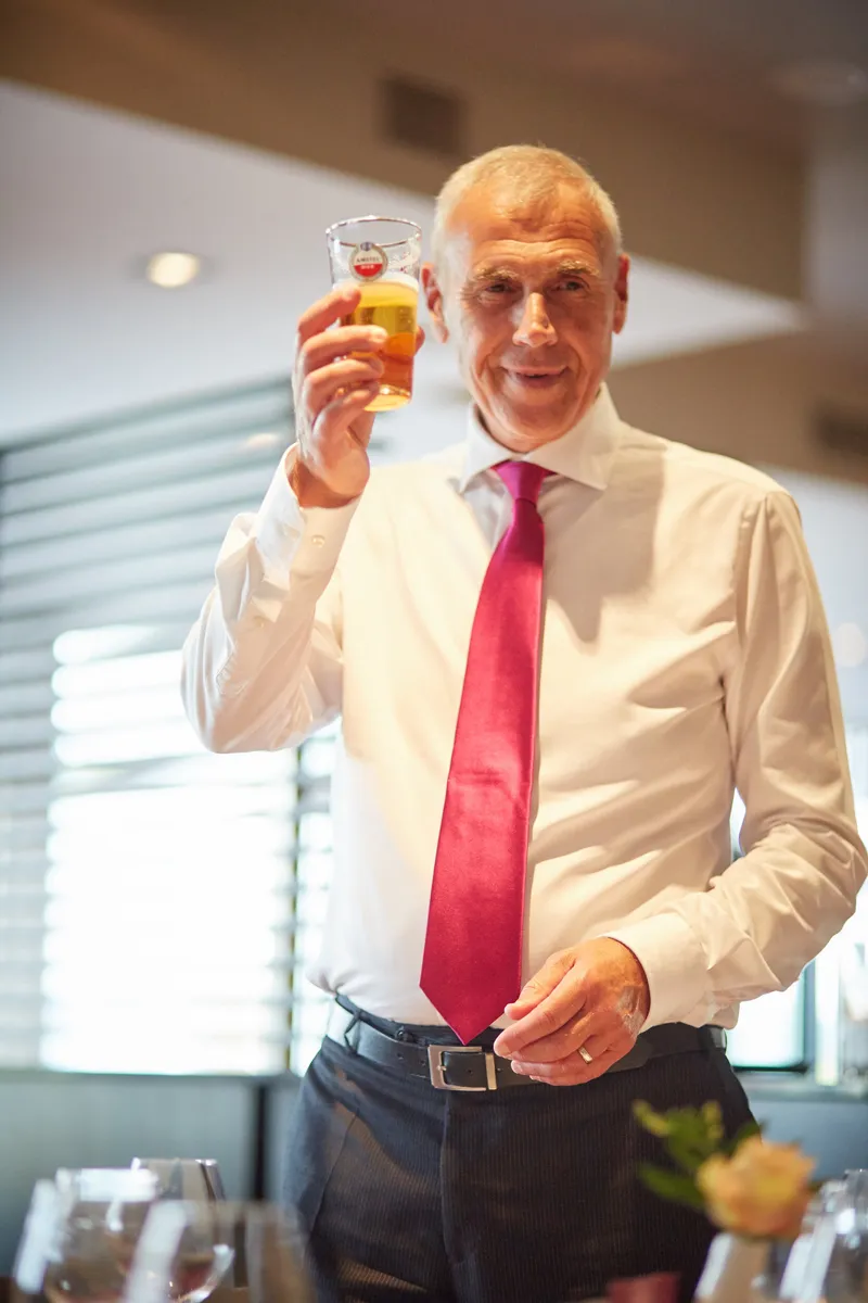 Een gast heft het glas voor een toost