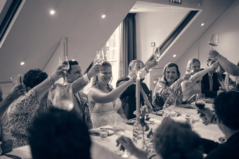 Zwart-wit: de gasten heffen het glas aan tafel