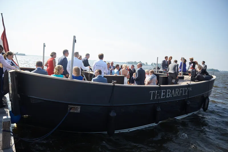 De gasten aan boord op het water