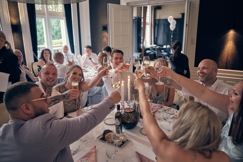 Gasten heffen hun glas aan tafel