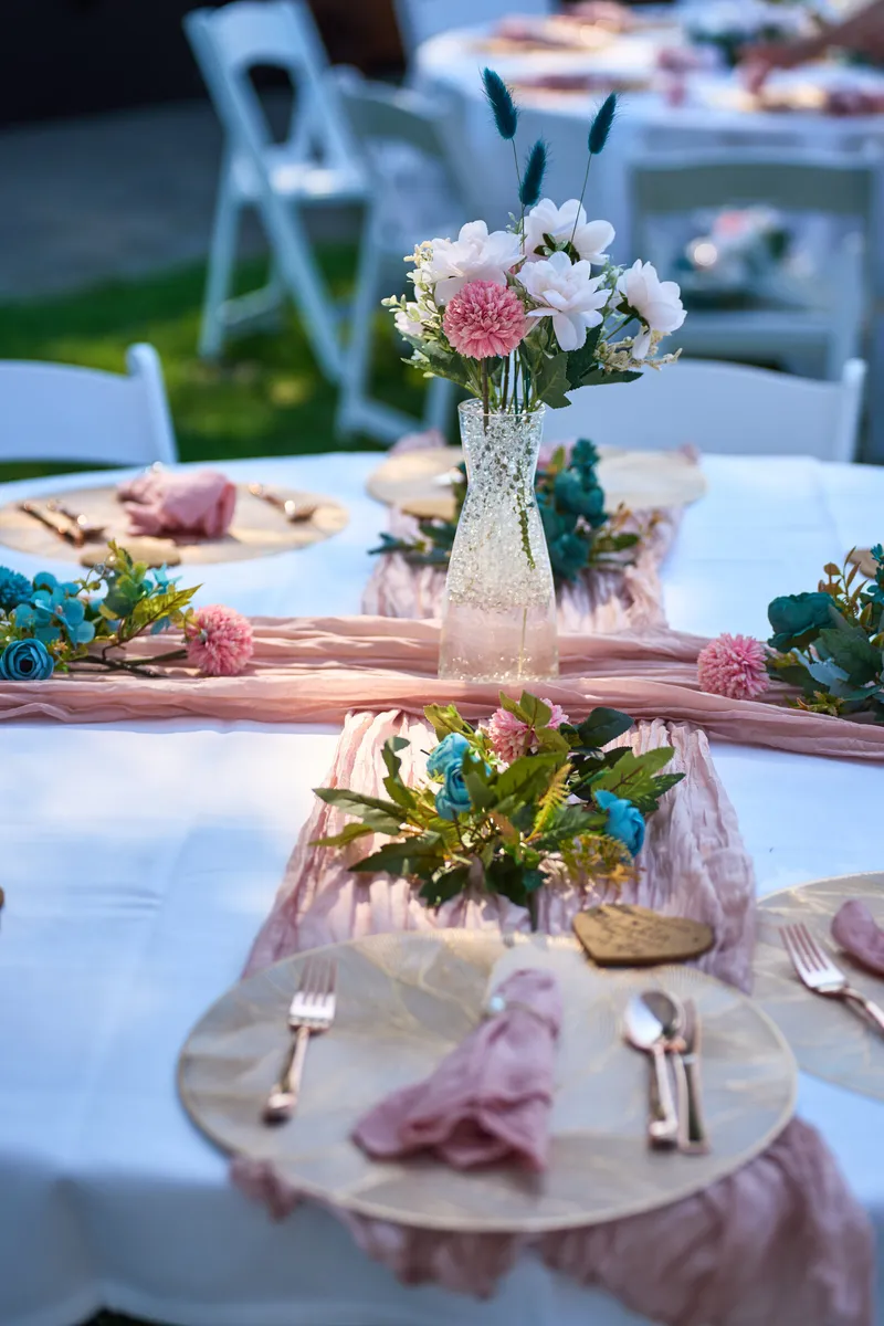 Bloemen en een roze loper op een gedekte tafel