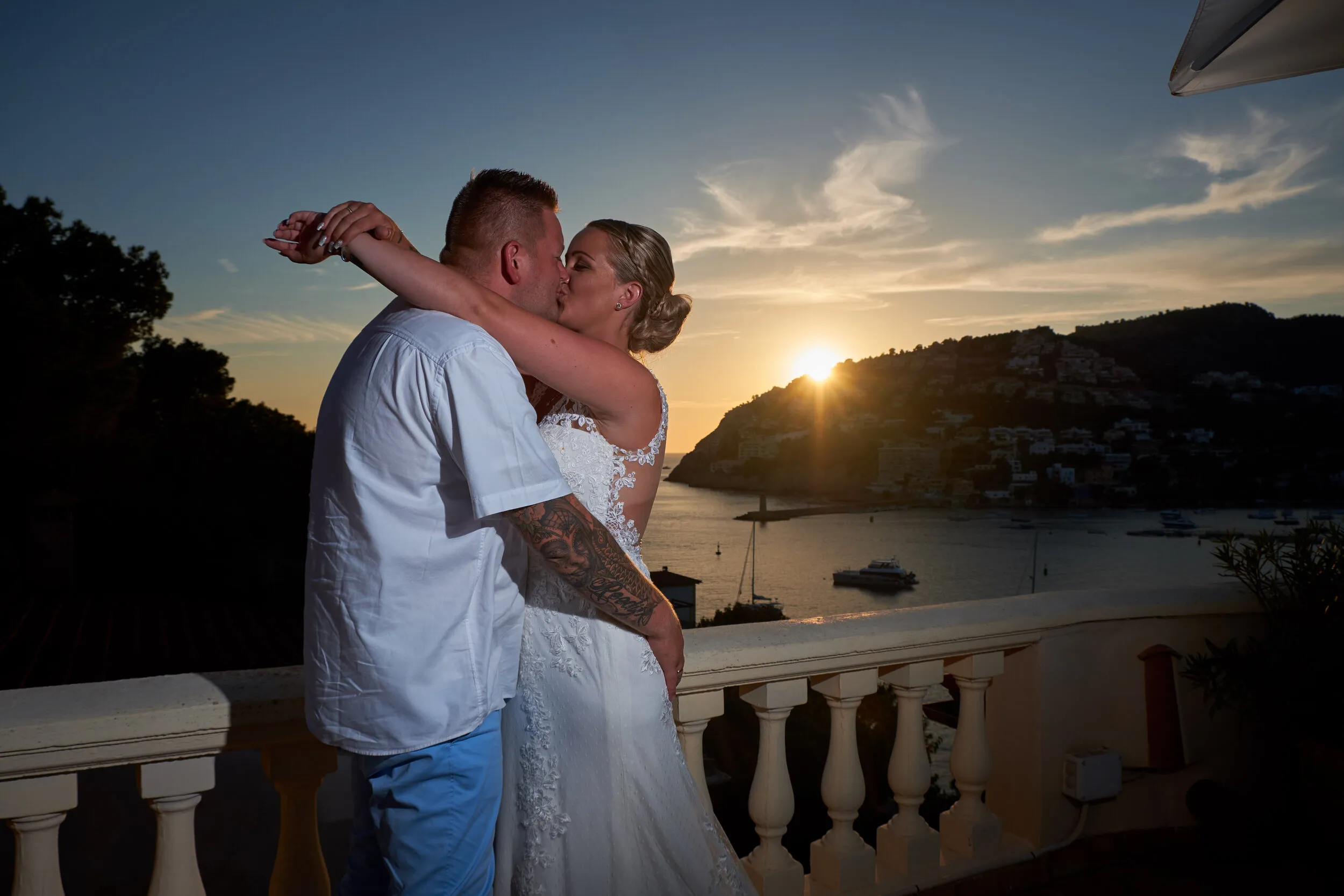Wesley en Stephanie kussen elkaar bij zonsondergang boven de baai van Port d'Andratx op Mallorca