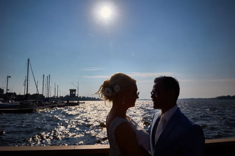Bas en Jooske als silhouet tegen de zon op het water