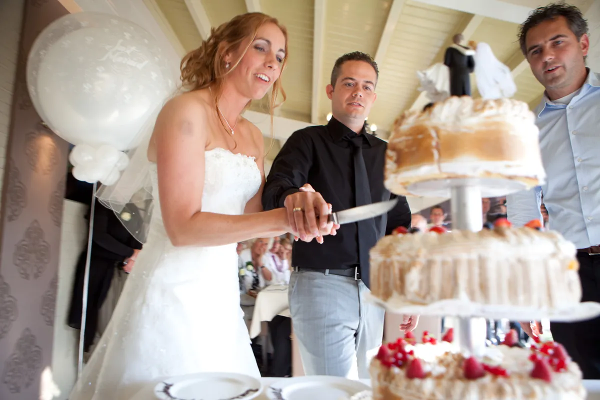 Inge en Harrie snijden de taart aan in de serre