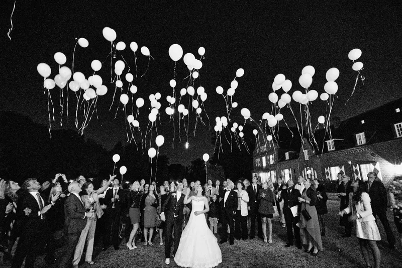 Alle gasten laten in het donker witte ballonnen op, in zwart-wit