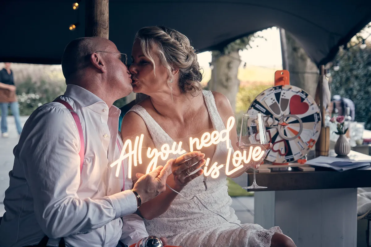 Bram en Elles kussen voor het neonbord ‘All you need is love’