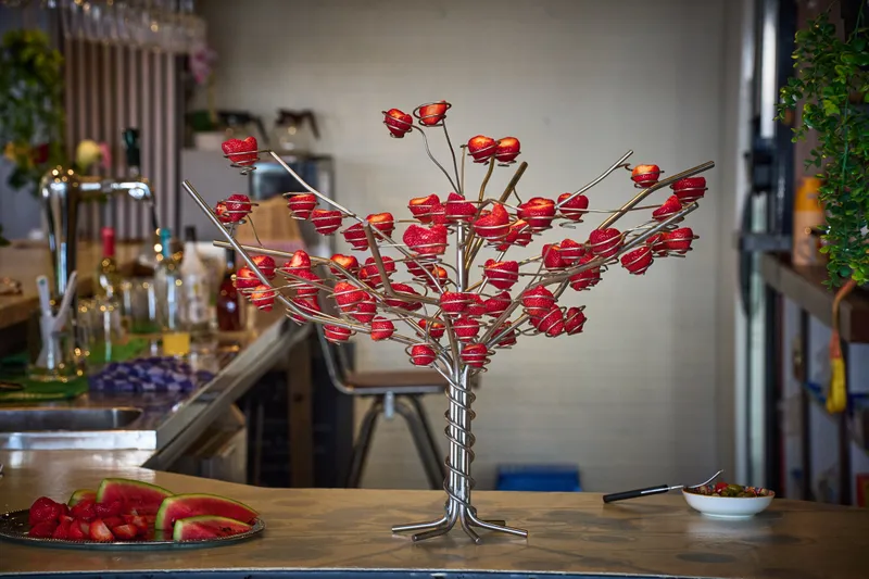 Een boompje met rode bloemen op de bar