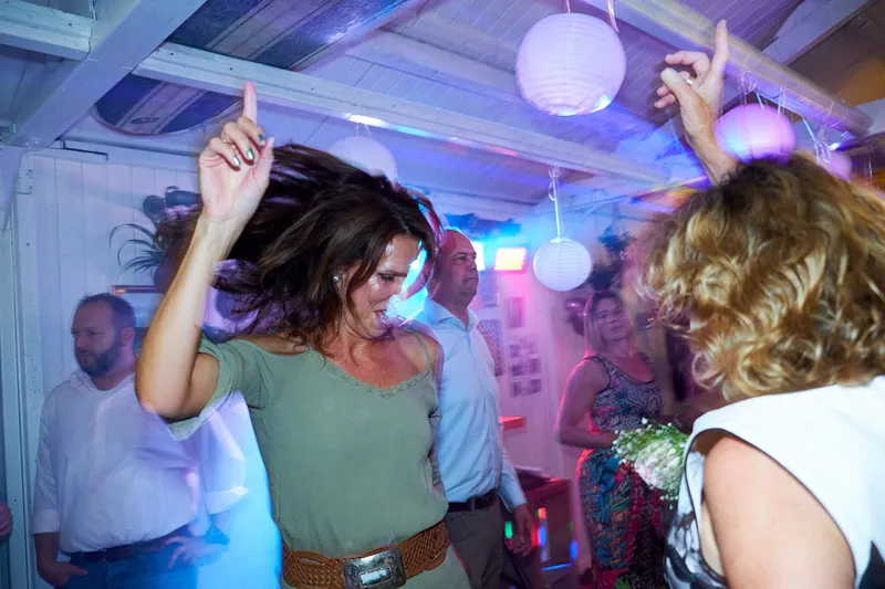 Een gast danst uitgelaten op het feest
