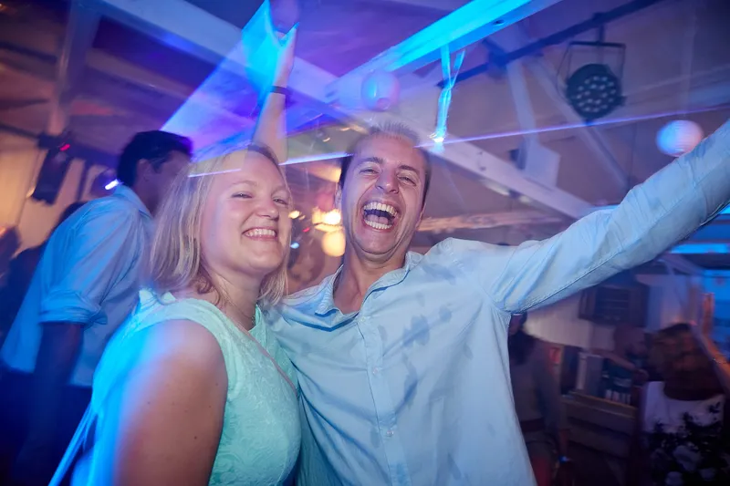 Twee gasten juichen in blauw licht