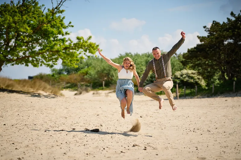 Elise en Erik springen samen in het zand