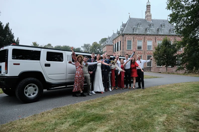 De hele groep voor de witte Hummer, met het kasteel erachter