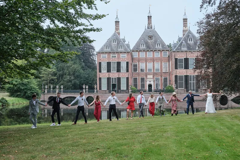 De groep loopt in een rij over het gazon voor Kasteel Duivenvoorde