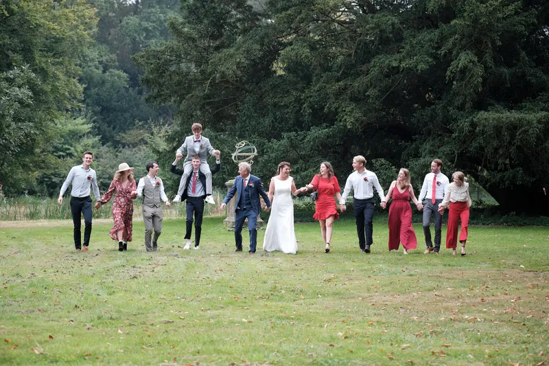 De groep loopt over het grote gazon onder de bomen