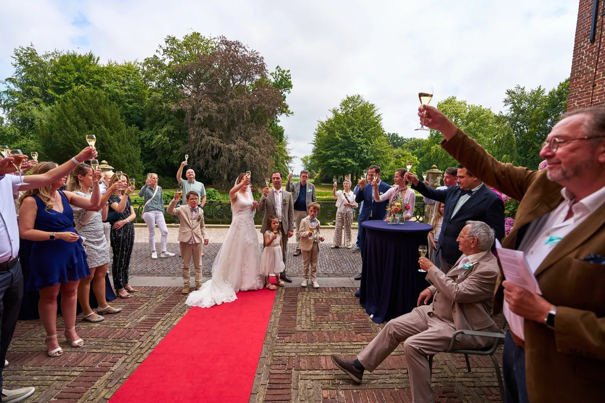 Gasten heffen hun glas als Rutger en Caroline naar buiten komen