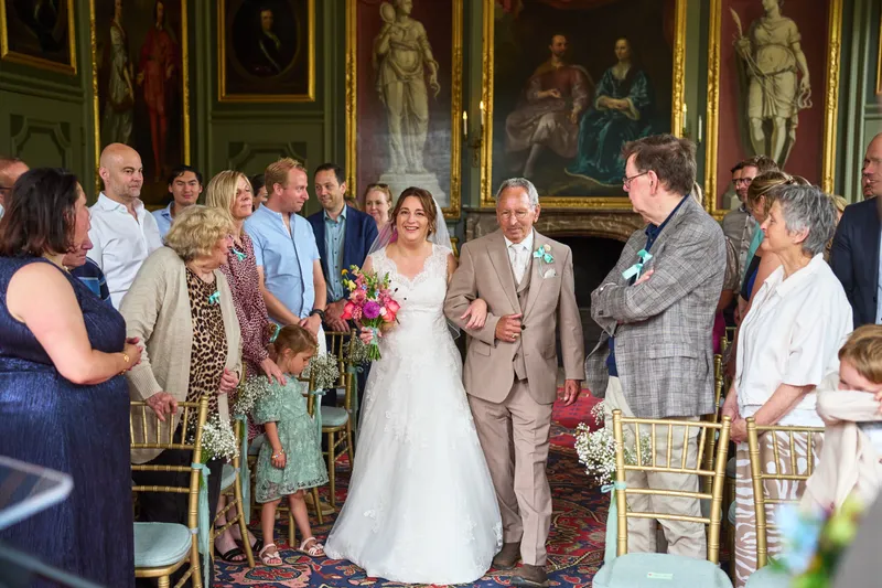 Caroline komt met haar vader de trouwzaal binnen