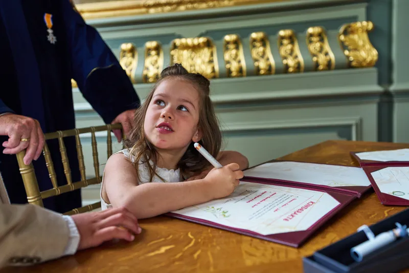 Hun dochter tekent aan de tafel van de trouwambtenaar
