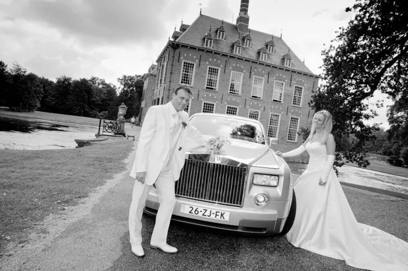 Zwart-wit: bruid en bruidegom bij een oude Rolls-Royce voor Kasteel Duivenvoorde