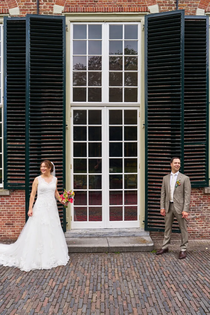 Rutger en Caroline voor de groene luiken en glazen deuren van het kasteel