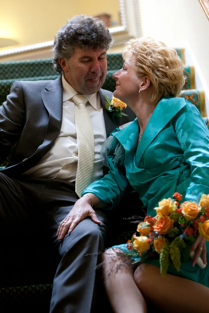 Erica en Rob op de trap, zij met haar oranje rozen