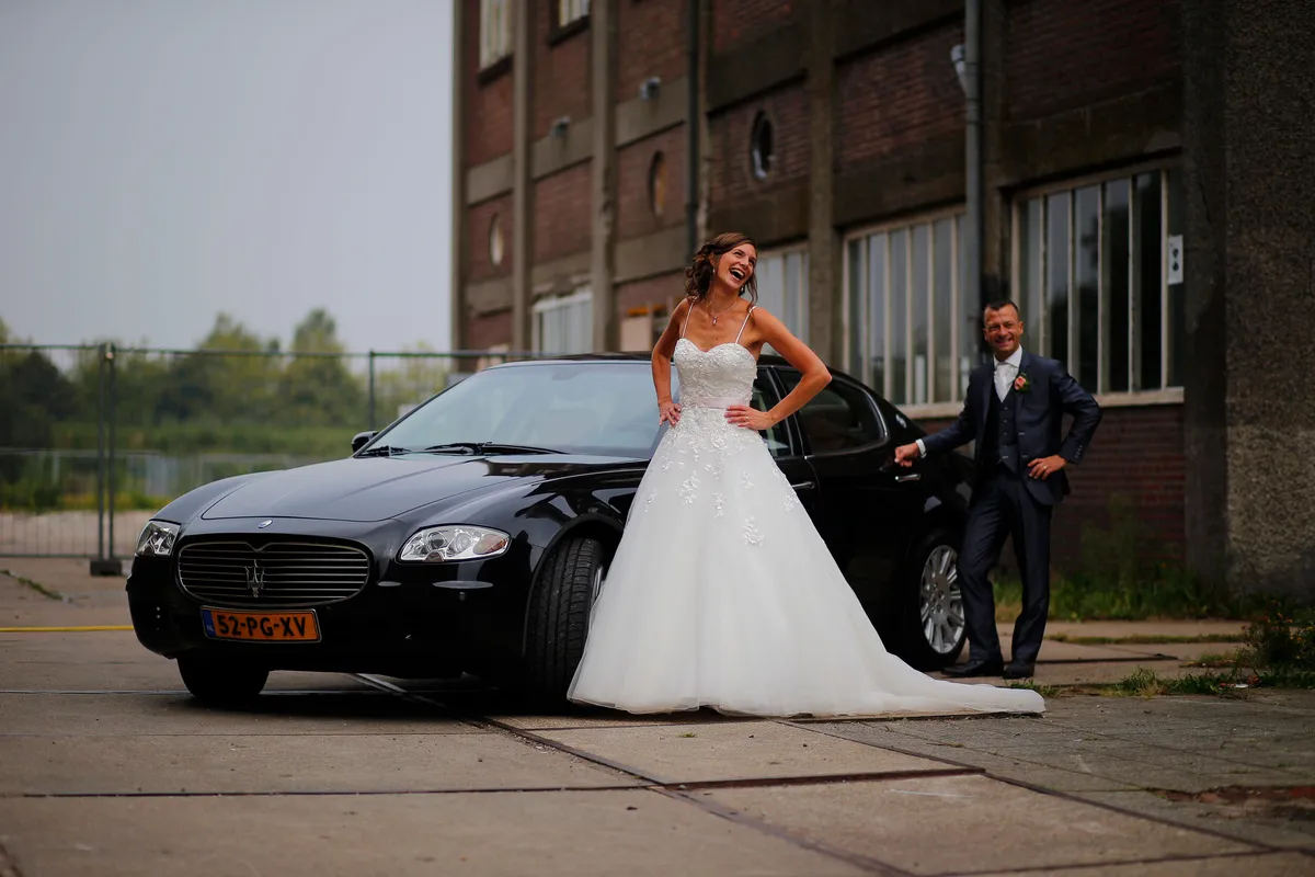 Aniek poseert bij de zwarte Maserati voor de Leerfabriek