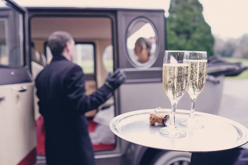 Twee glazen bubbels op een dienblad bij de oldtimer