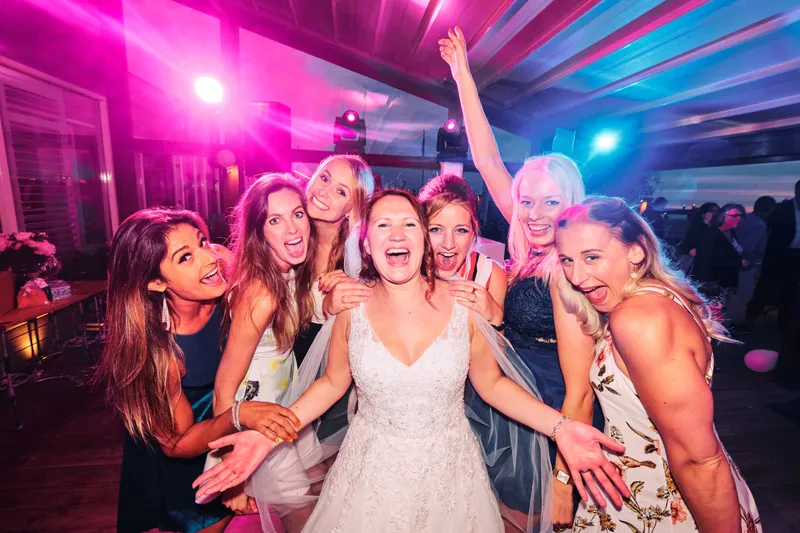 Victoria lacht met vriendinnen in roze licht
