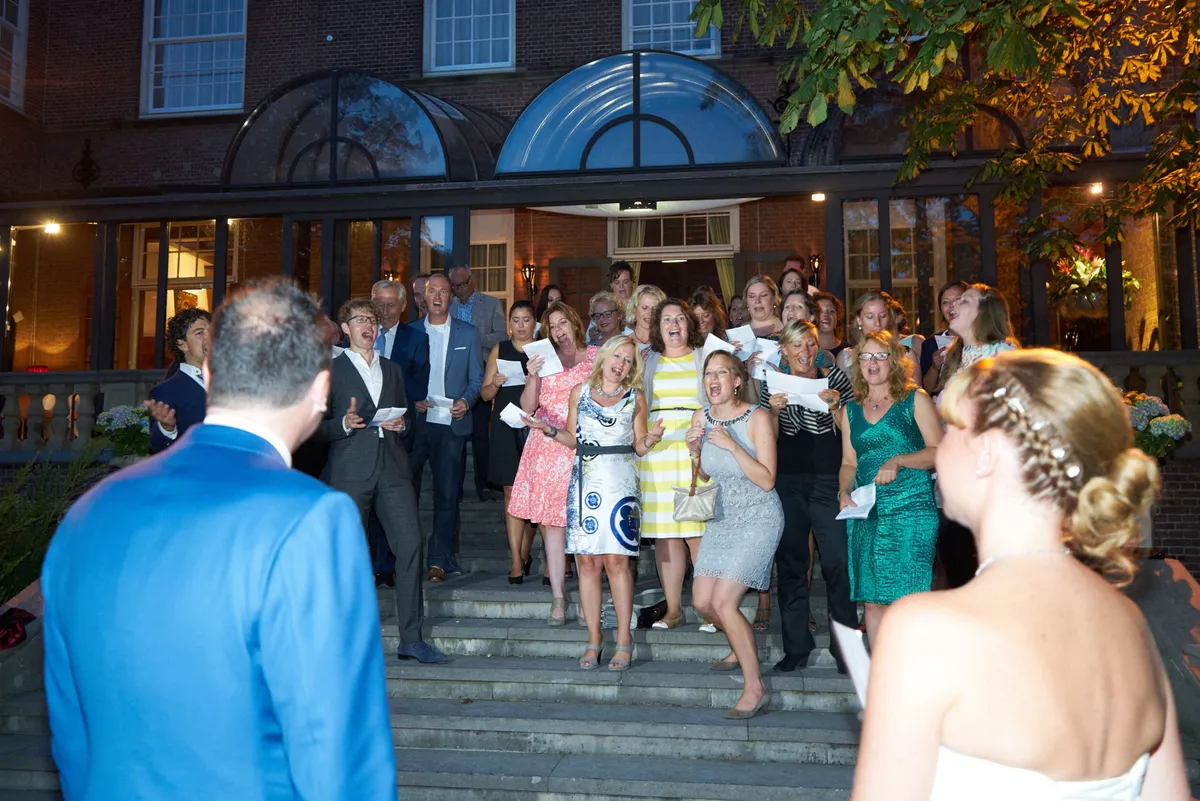 De gasten verzamelen zich in de avond op de trap voor het kasteel