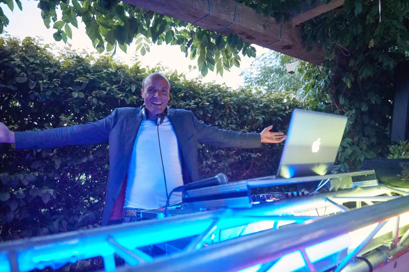 De dj achter de draaitafel met de armen wijd