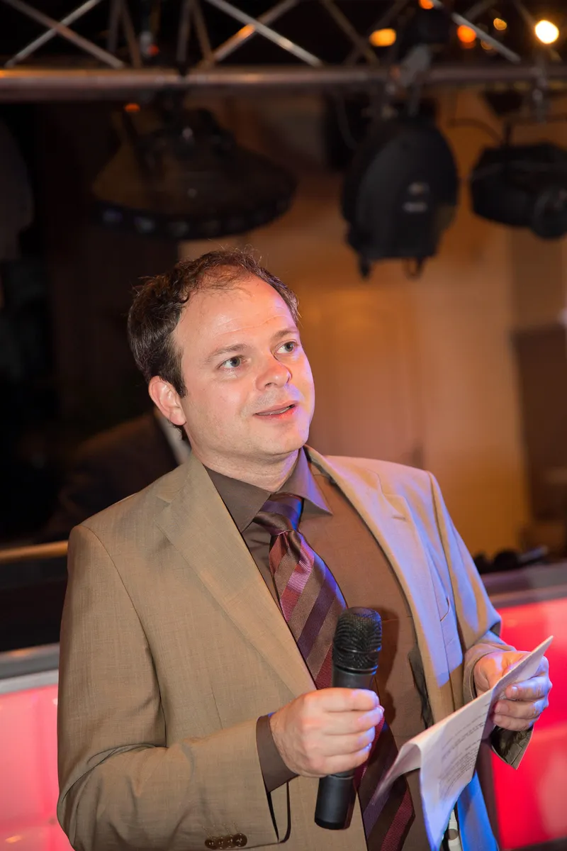 Een man met een microfoon op het feest