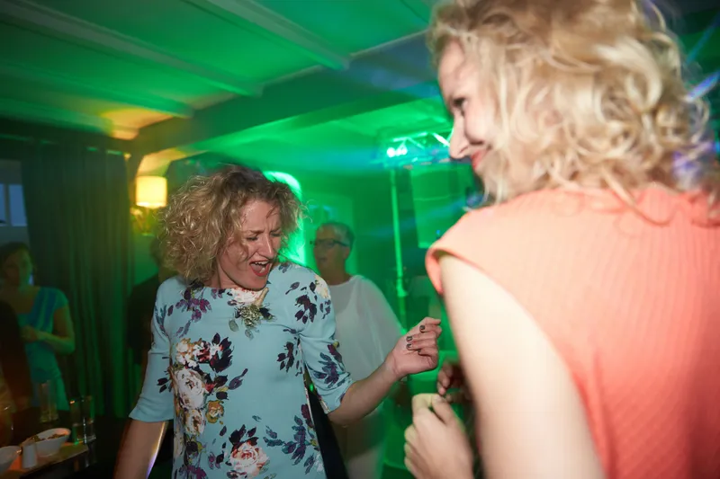 Twee gasten dansen in groen licht